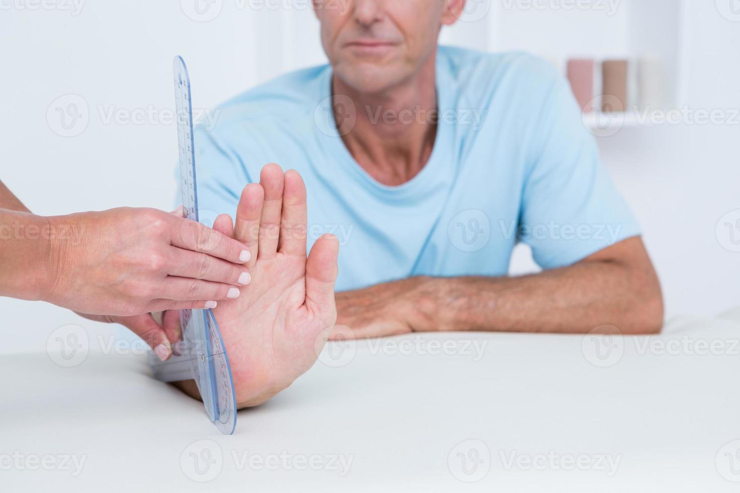 Doctor measuring wrist with goniometer photo