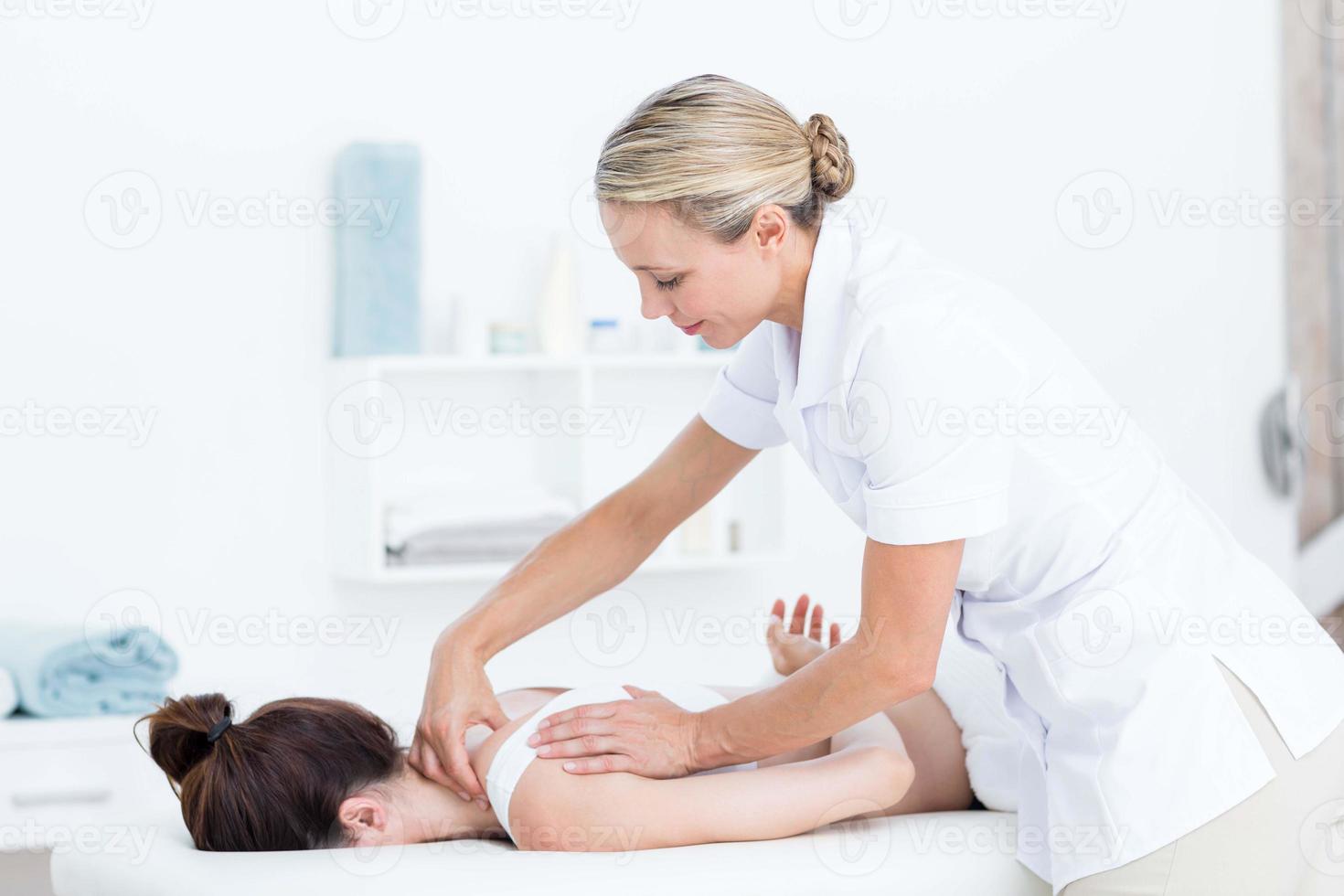 Physiotherapist doing neck massage photo
