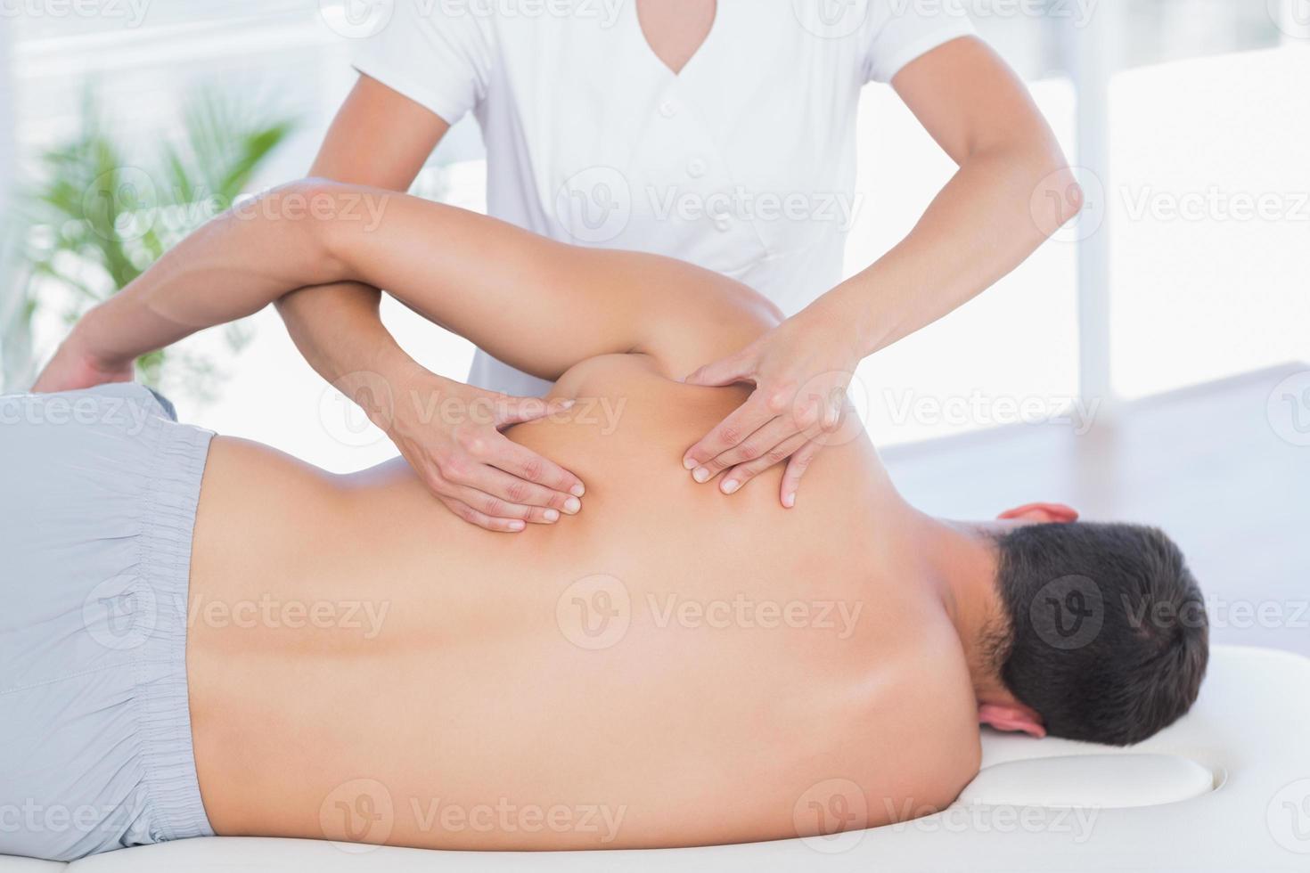 fisioterapeuta haciendo masaje de espalda a su paciente foto