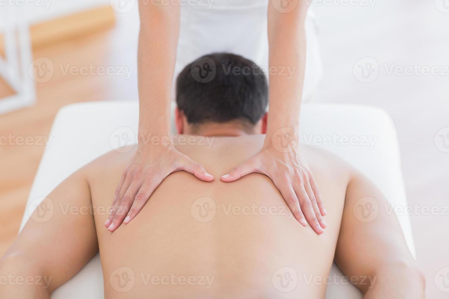Physiotherapist doing back massage to her patient photo