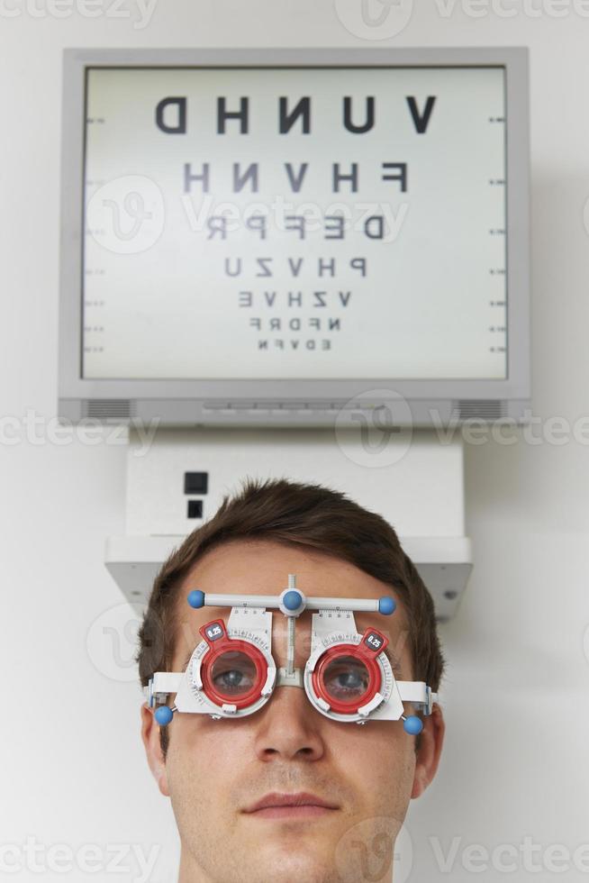 hombre que tiene prueba de vista en optometrista foto