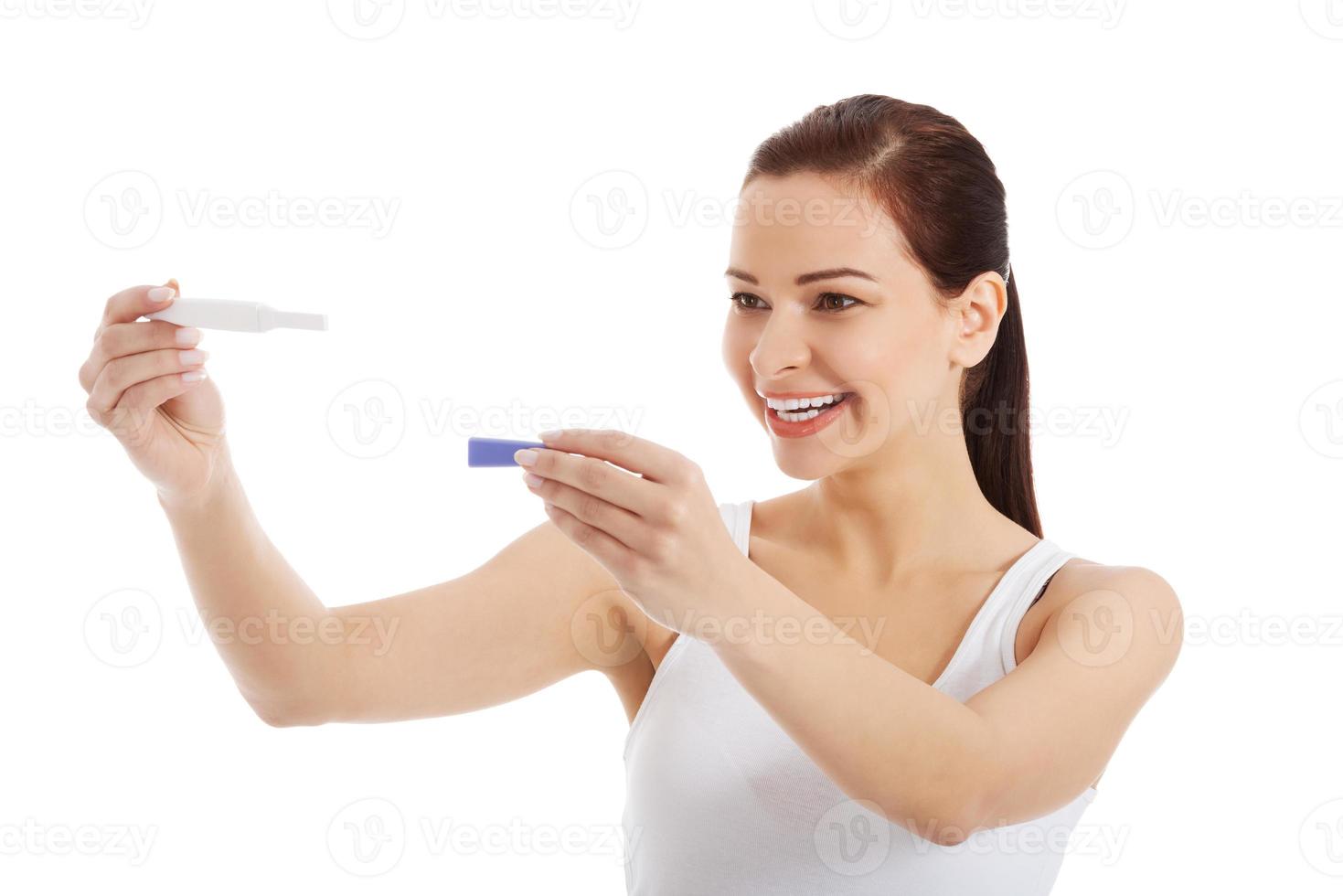 Happy beautiful young woman with pregnancy test. photo