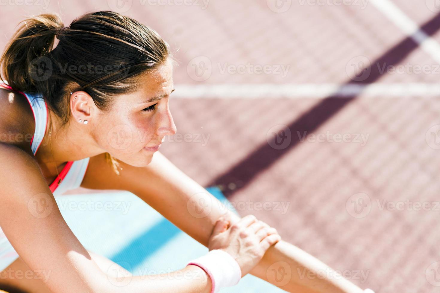 Beautiful young athletic woman stretching in summer photo