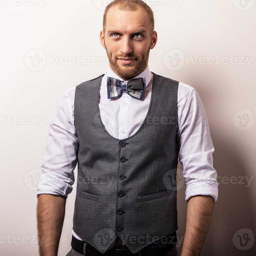 elegante joven guapo en chaleco gris y corbata de moño. Foto de stock en Vecteezy