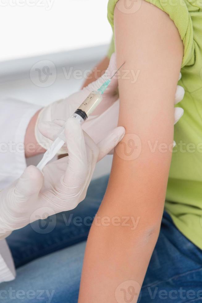 Doctor doing injection at little boy photo