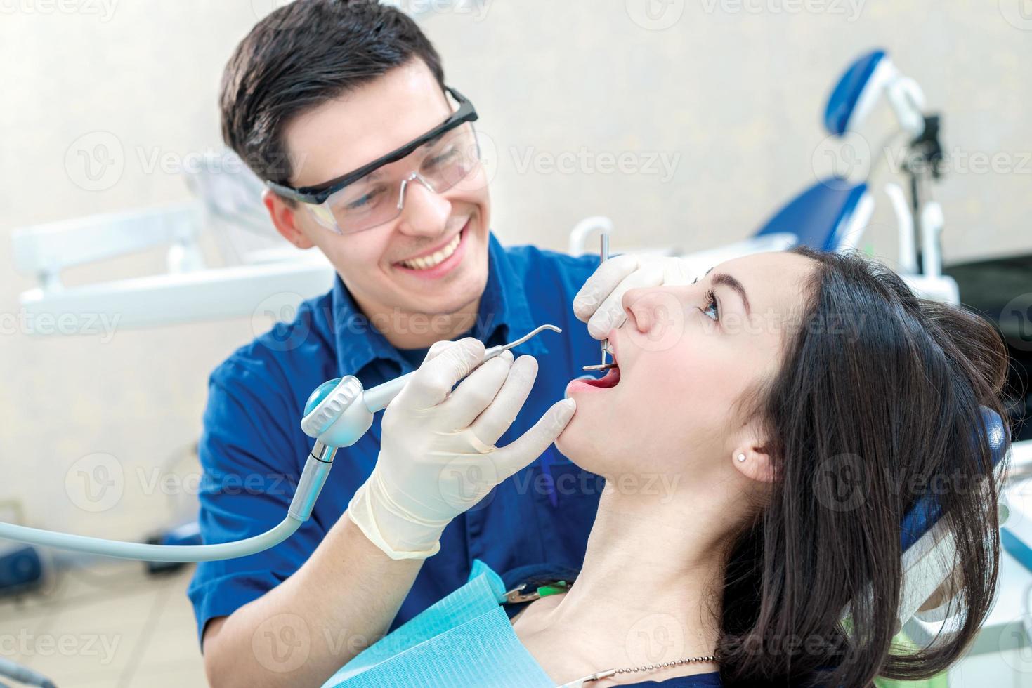 sonriente médico dentista trata los dientes. sonriente paciente femenino sitt foto