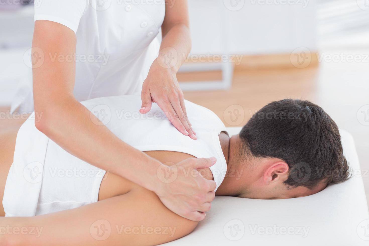 Physiotherapist doing back massage photo