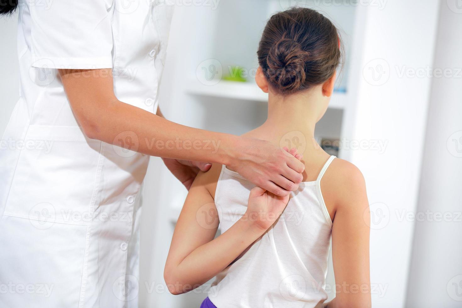 Chiropractic Doctor Adjusts Elementary Girl photo