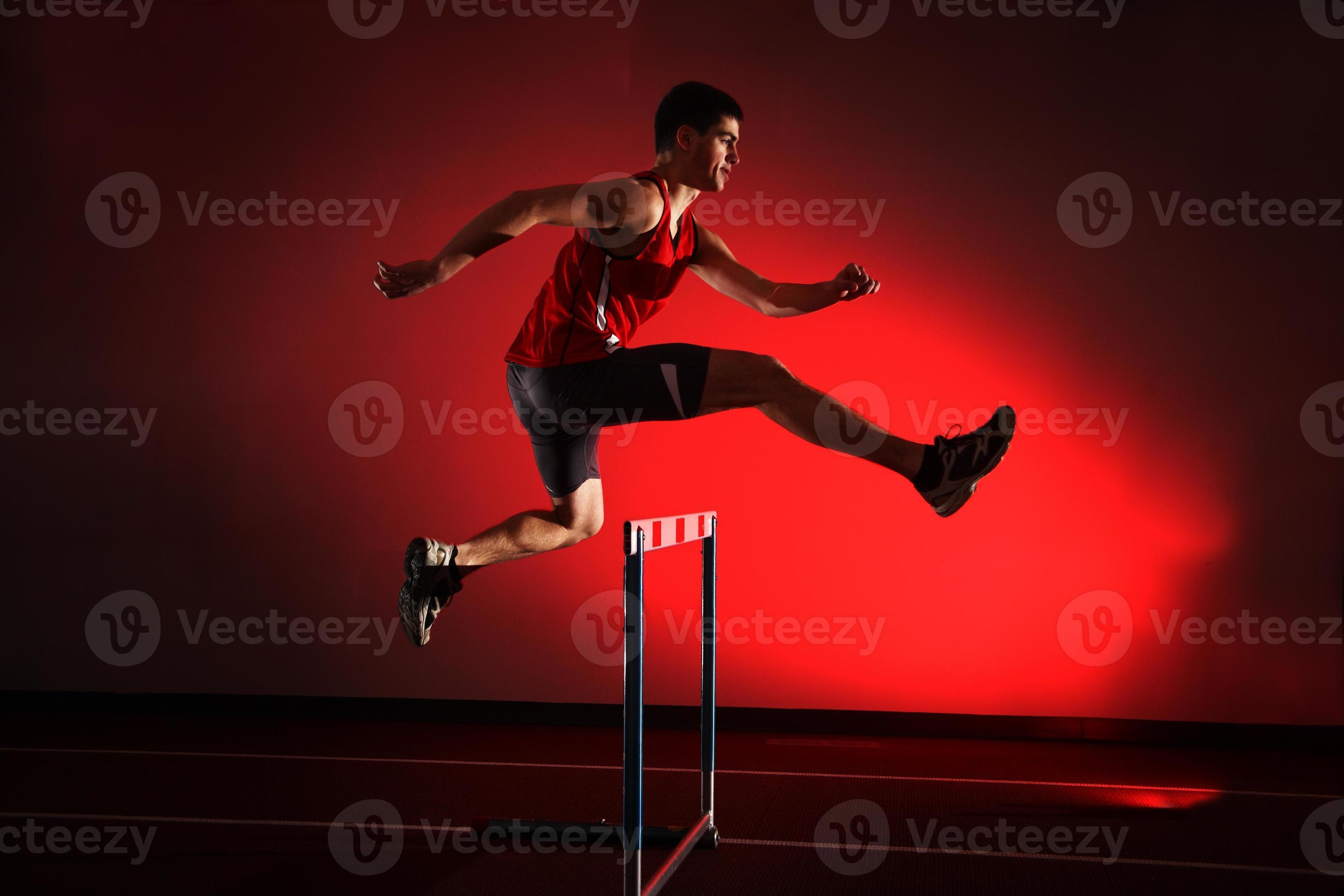 athlete running hurdles isolated on red background 963235 Stock Photo