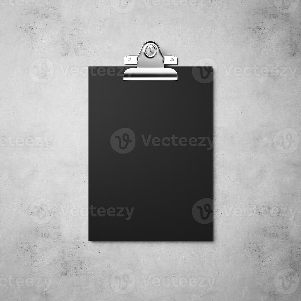 Black paper with clip on the concrete background photo