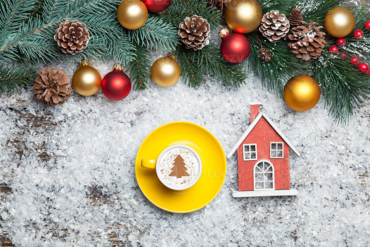 Cappuccino with christmas tree shape and toy home on artificial photo