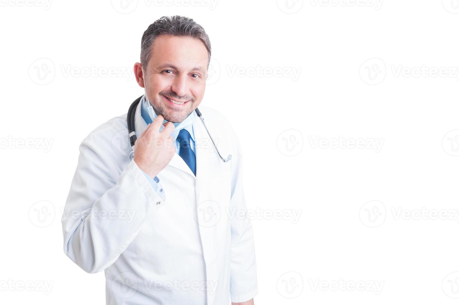 Friendly smiling doctor or medic removing protective surgical ma photo