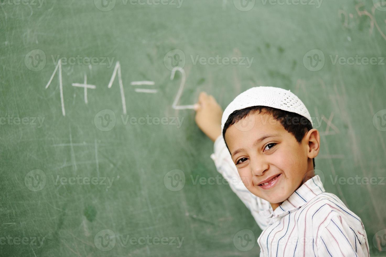 Arabic Muslim kid writing on blackboard in classroom, math 965267 Stock Photo at Vecteezy