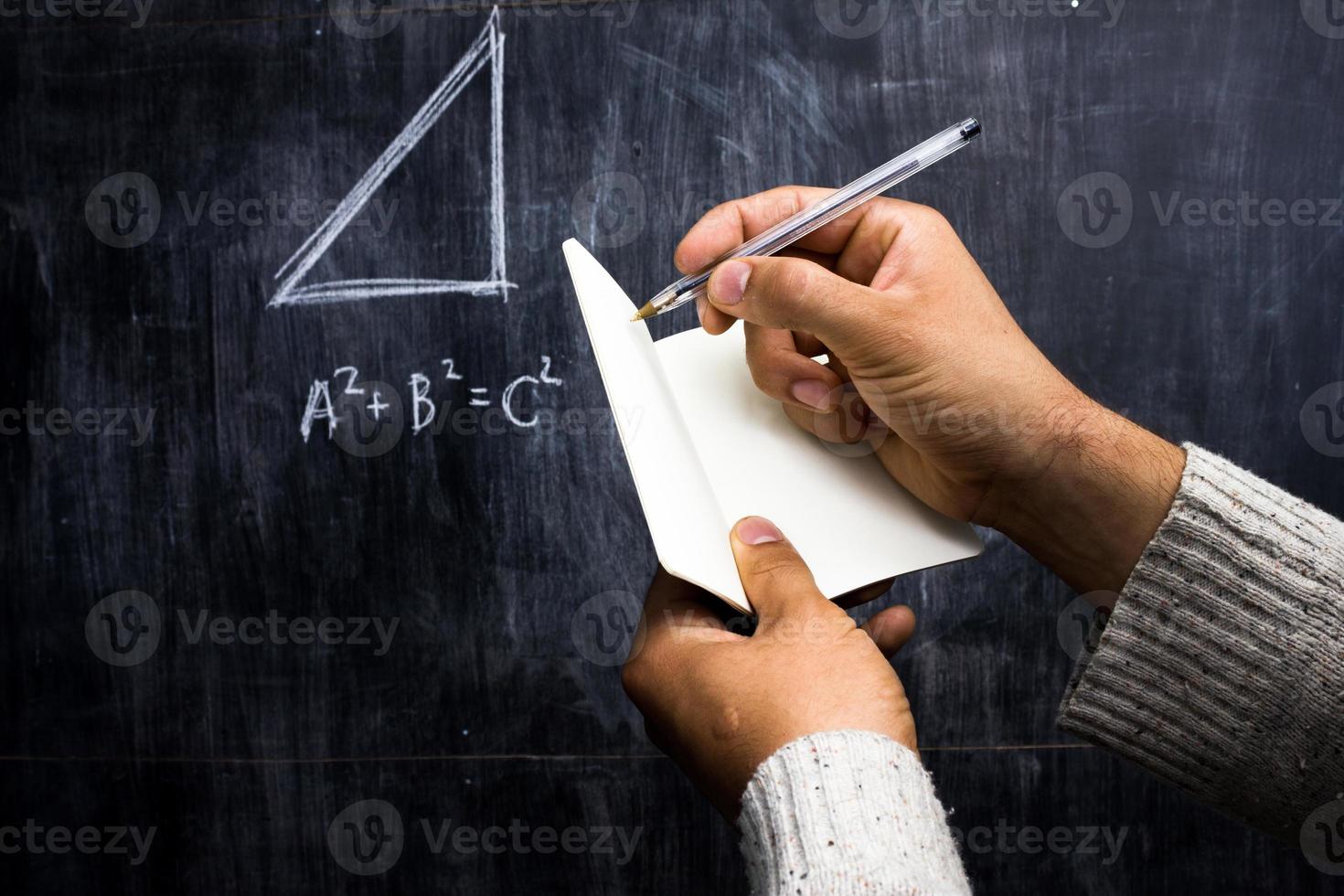 Hombre tomando notas del teorema de matemáticas en la pizarra foto
