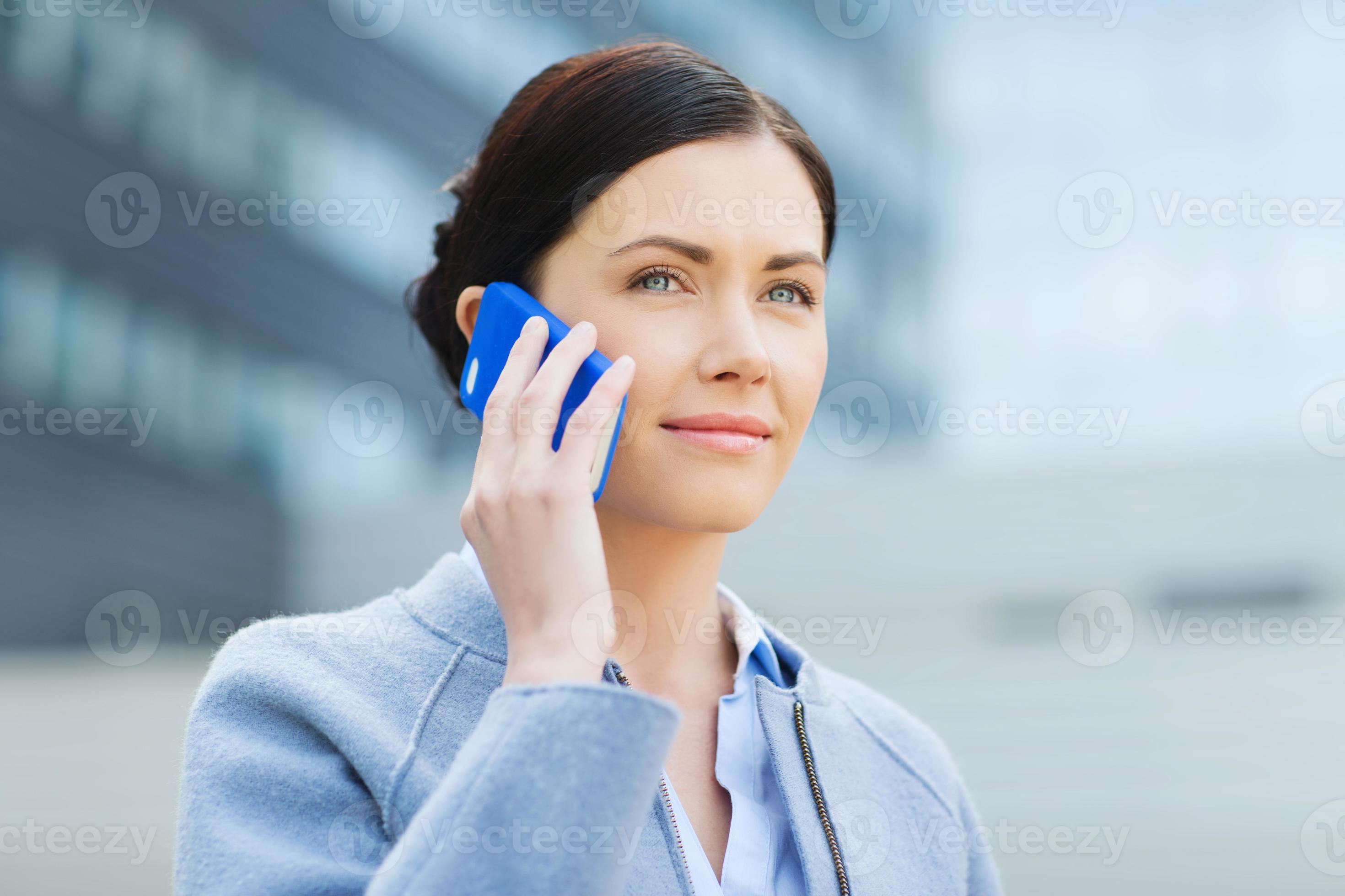 joven empresaria sonriente llamando en teléfono inteligente foto