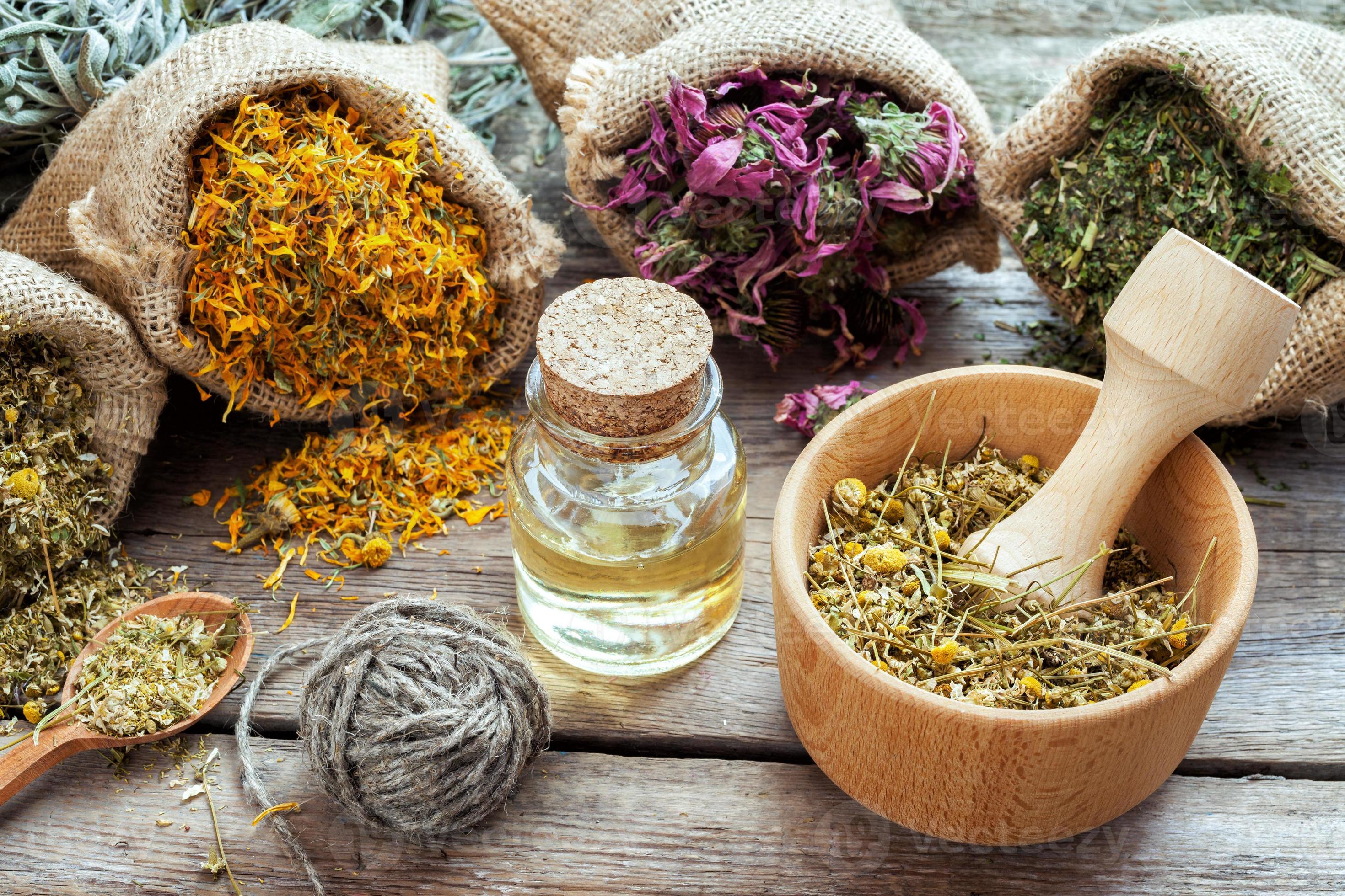 Download Healing herbs in hessian bags, mortar with chamomile and oil for f...