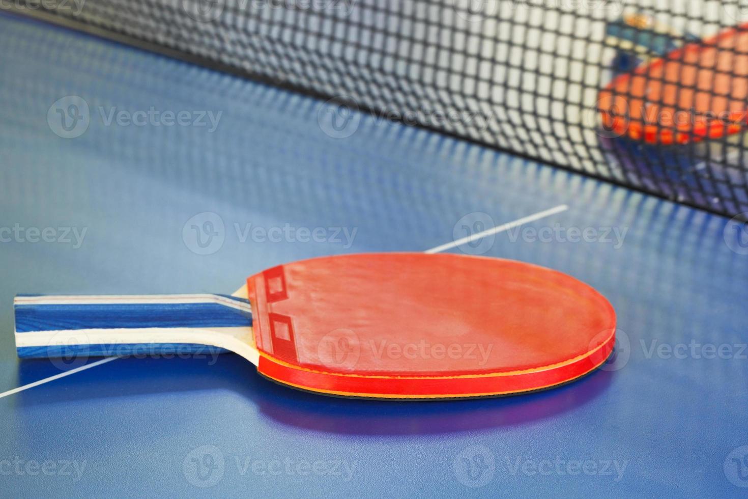 Dos raquetas de tenis rojas en la mesa de ping pong foto