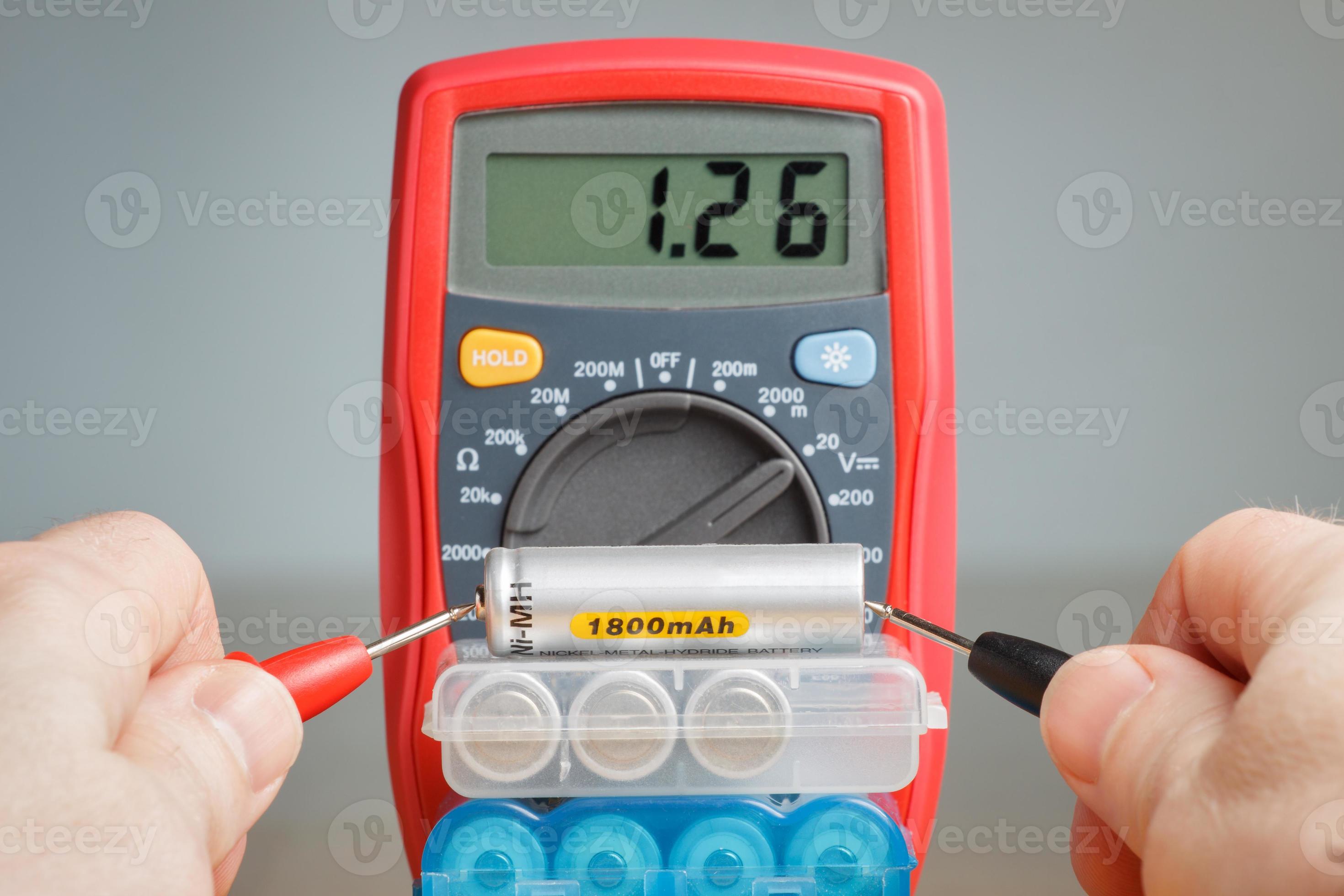 Measuring battery voltage with multimeter 991390 Stock Photo at Vecteezy
