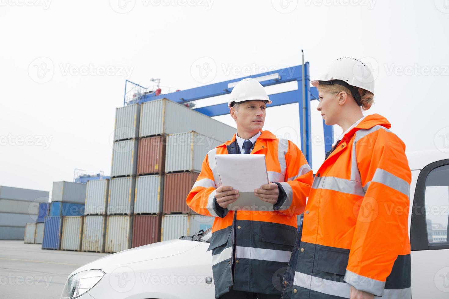 Workers conversing in shipping yard photo