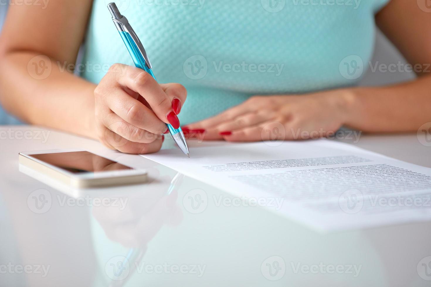 Young woman signs a contract photo