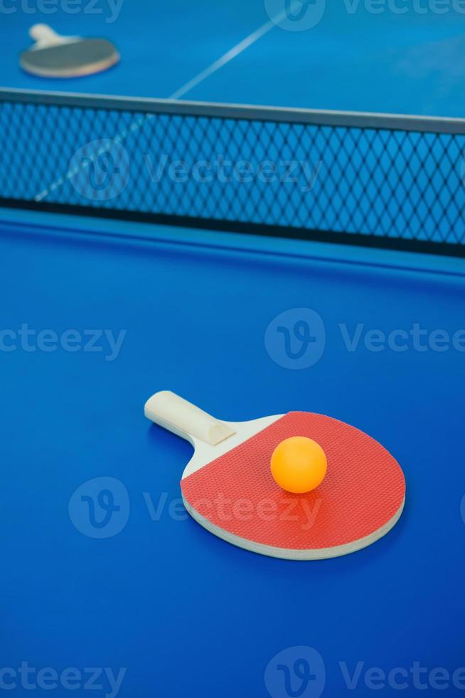 raqueta de ping-pong y pelota y red en la mesa de ping-pong foto