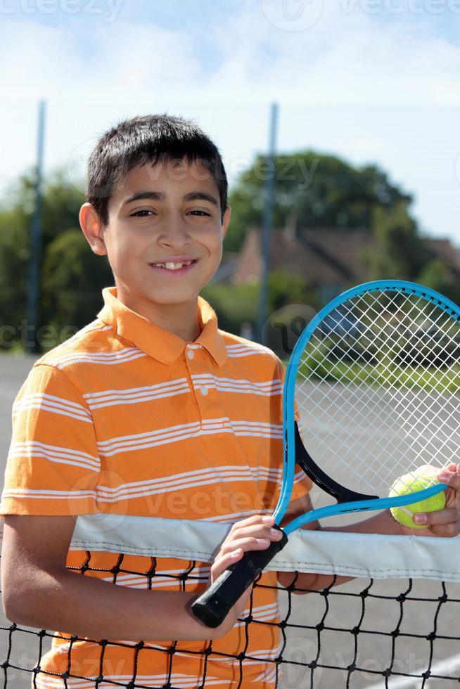Boy Holding Tennis Ball And Racket Stock Photo