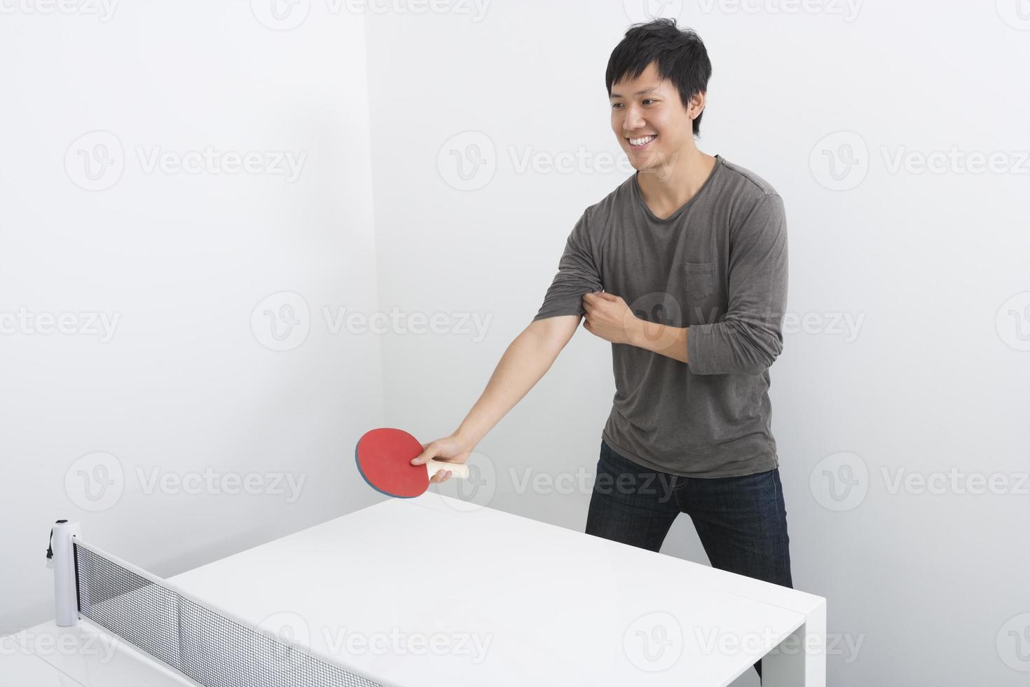 apuesto hombre adulto medio jugando tenis de mesa foto