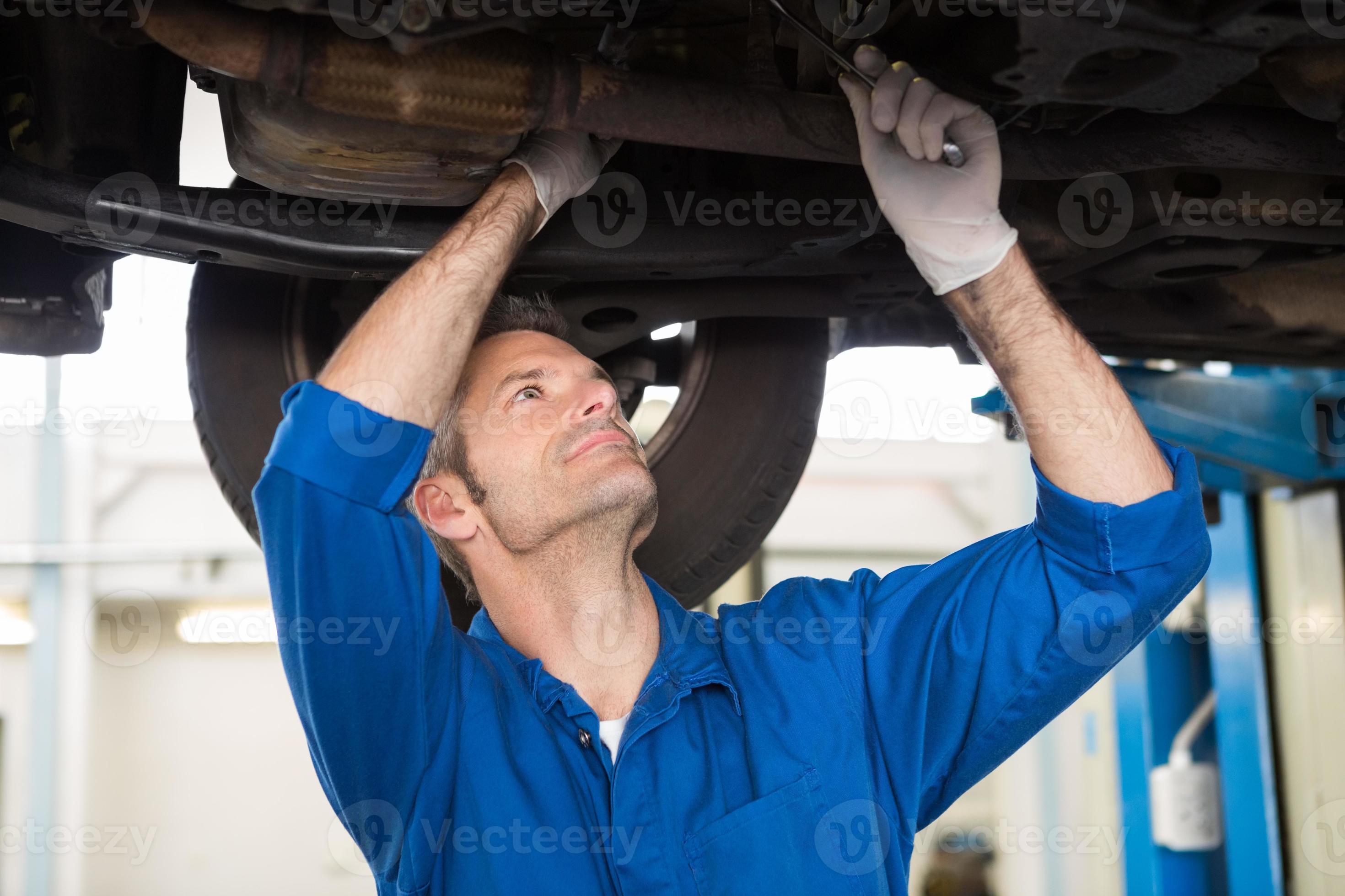 Mechanic examining under the car photo