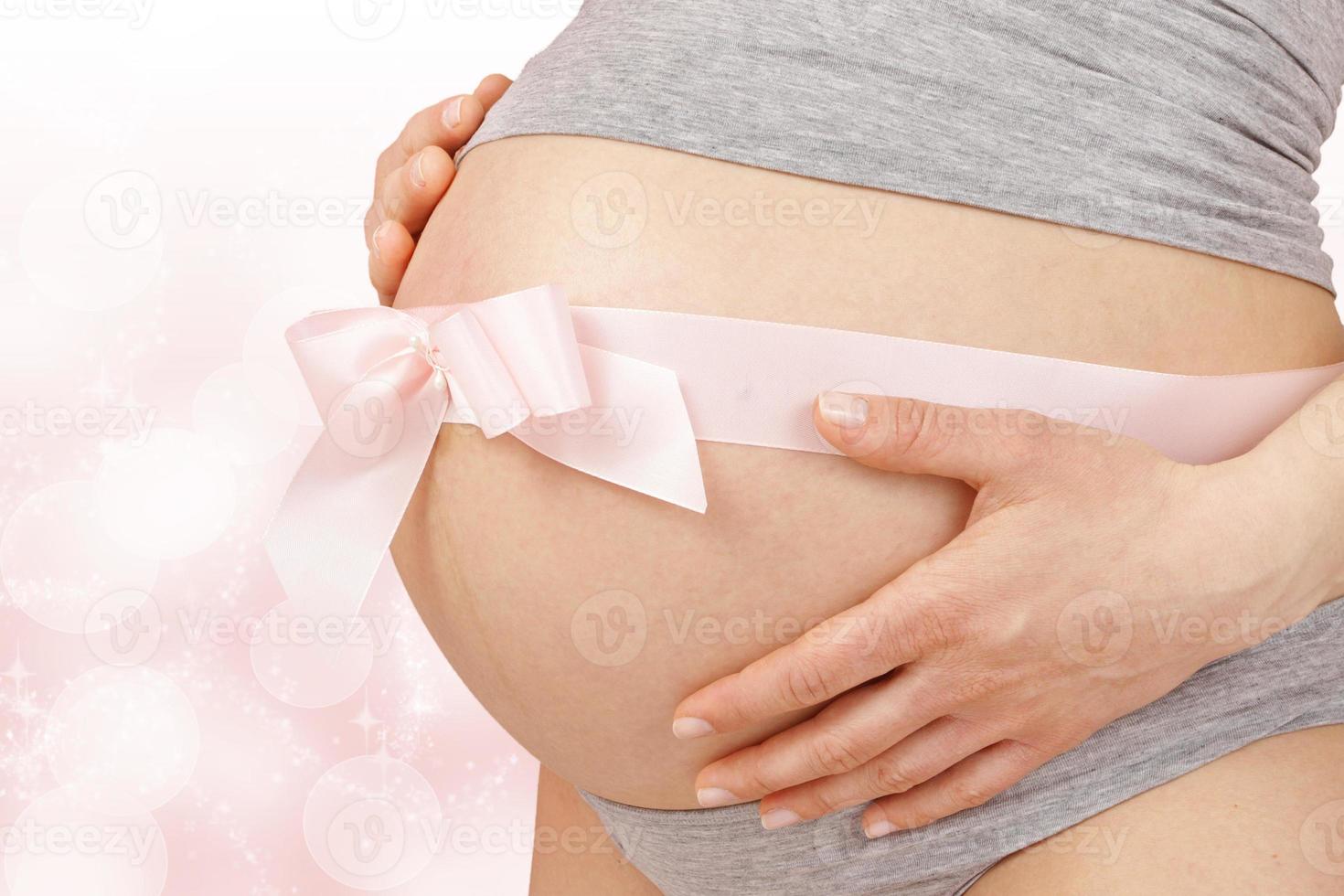 Pregnant woman embracing her belly photo