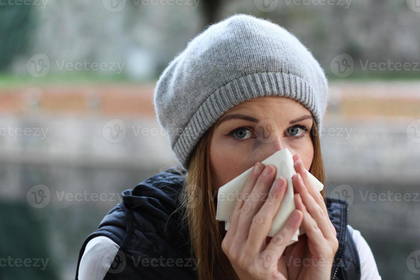 Woman blowing into tissue photo