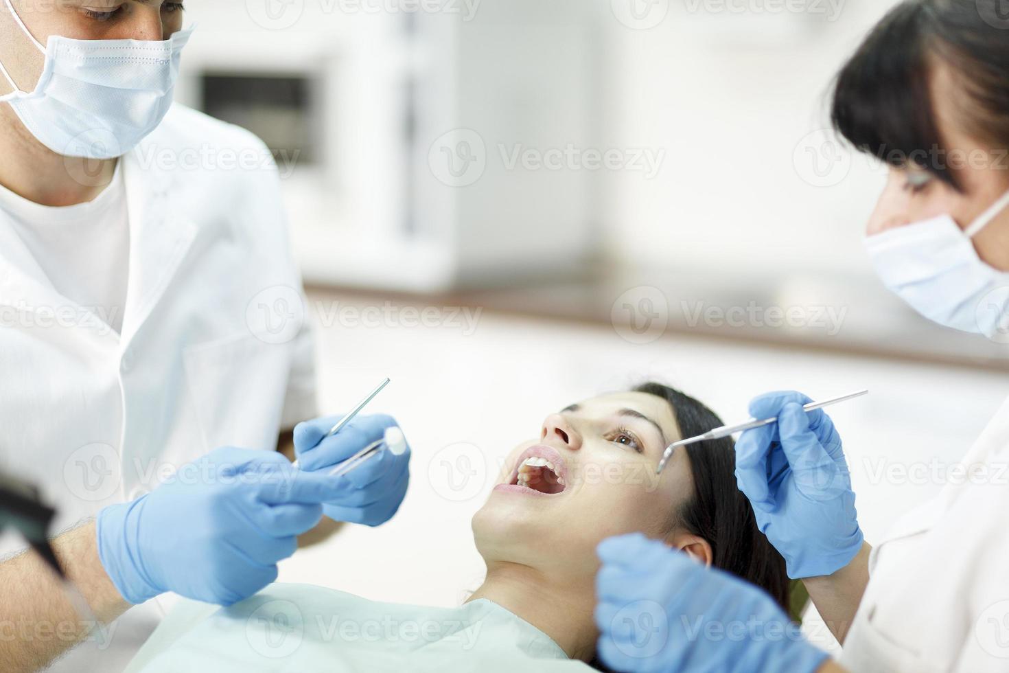 paciente con dos dentistas foto