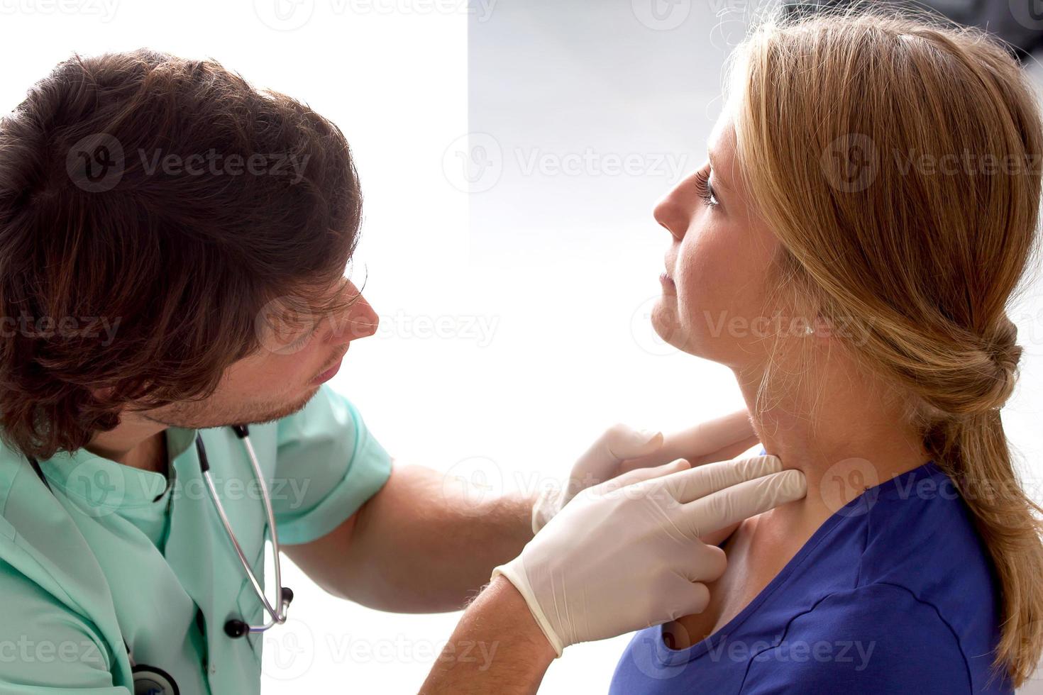 médico revisando los ganglios linfáticos foto