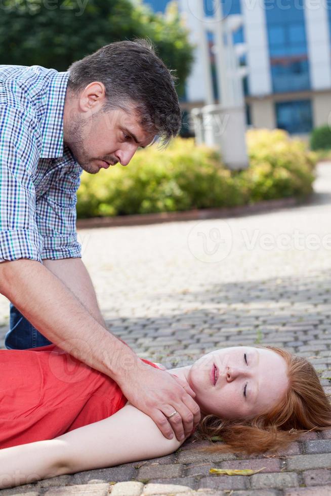hombre ayudando a mujer inconsciente foto