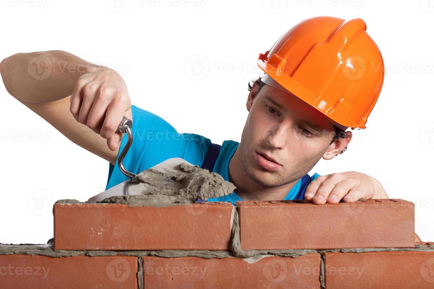Concentrated bricklayer putting photo