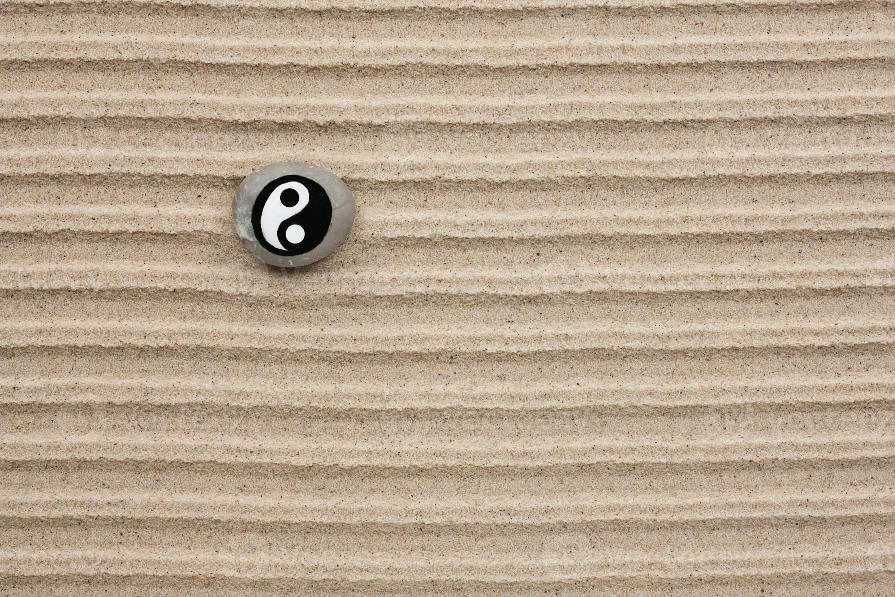 Stone with a yin-yang lies on the sand 1014674 Stock Photo at Vecteezy