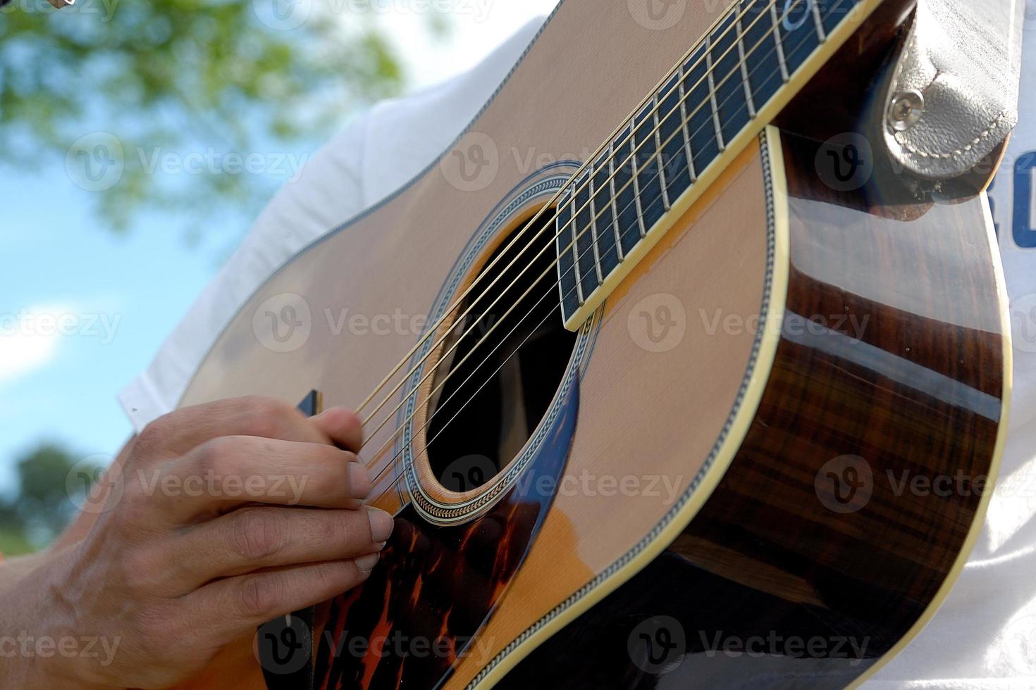 Person playing a guitar outdoors photo