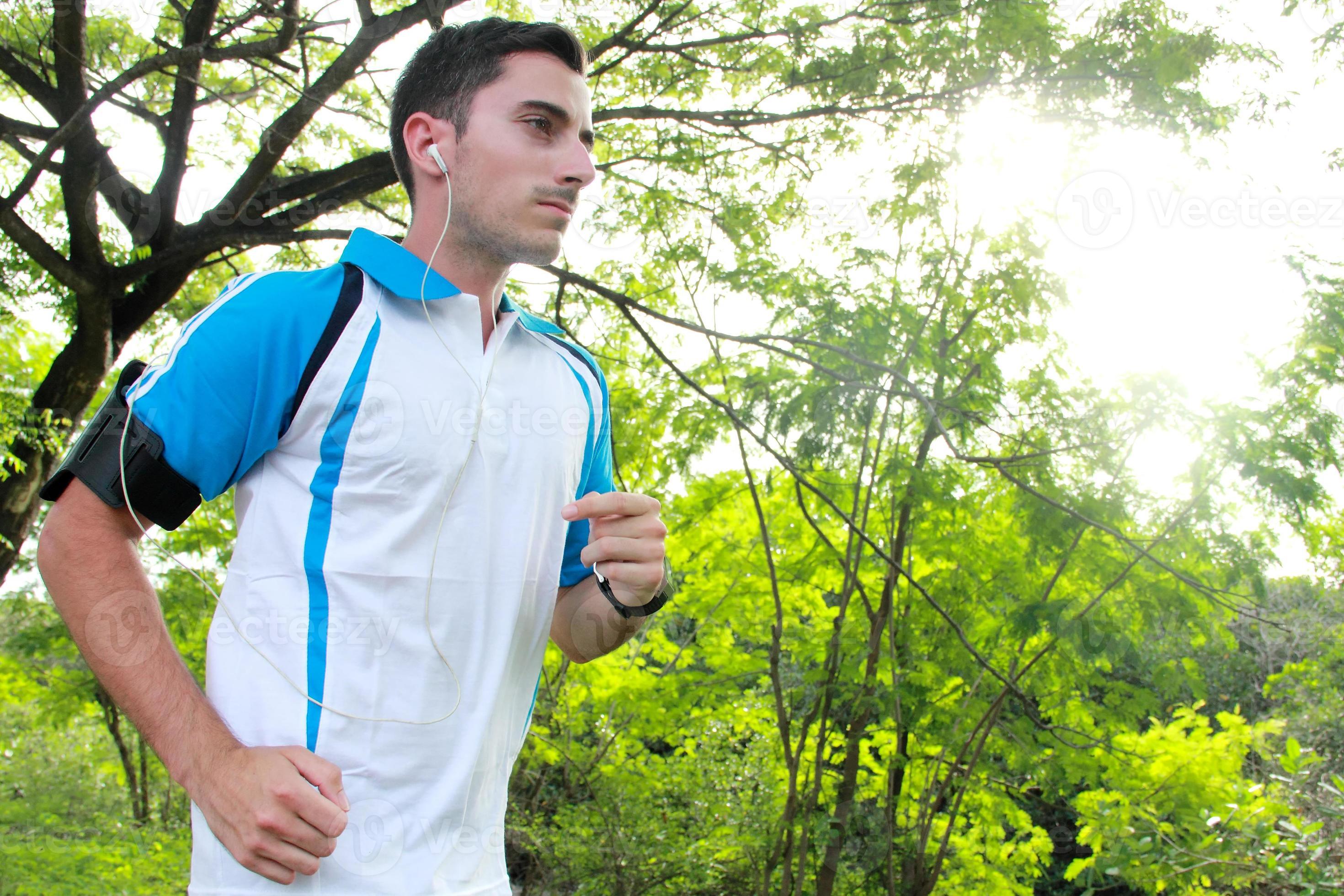 sporty fit young man jogging while listening music photo