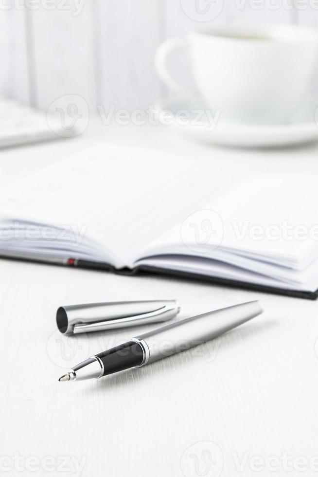 silver roller pen with notebook photo