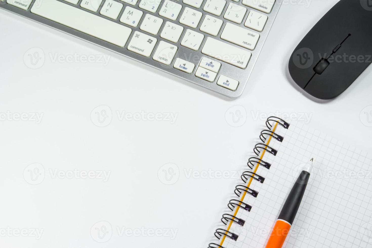 cuaderno en blanco con bolígrafo y teclado en la oficina foto