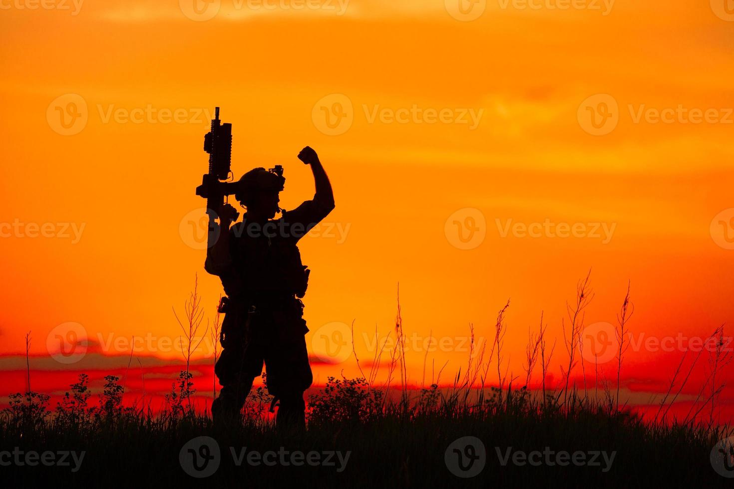 silueta de soldado militar u oficial con armas al atardecer foto