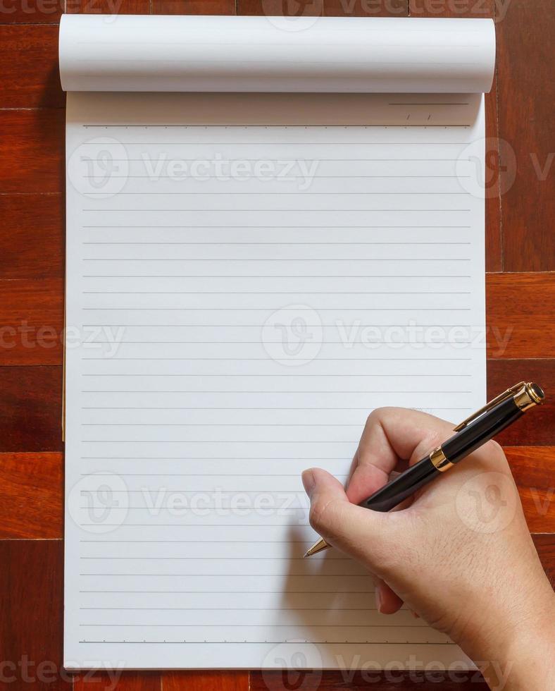 Escribir a mano en el cuaderno con lápiz. foto