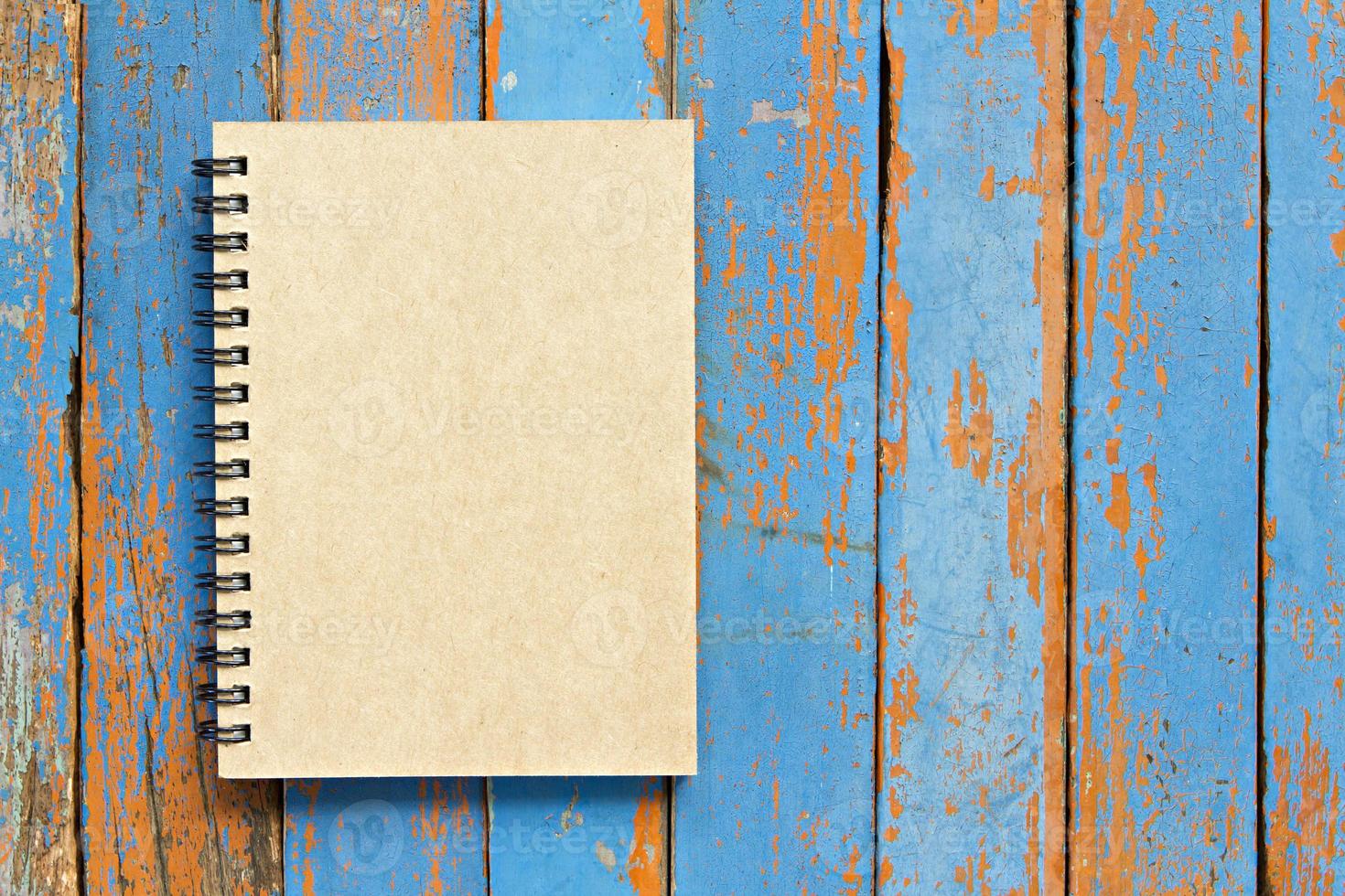 Brown notebook on wooden background photo