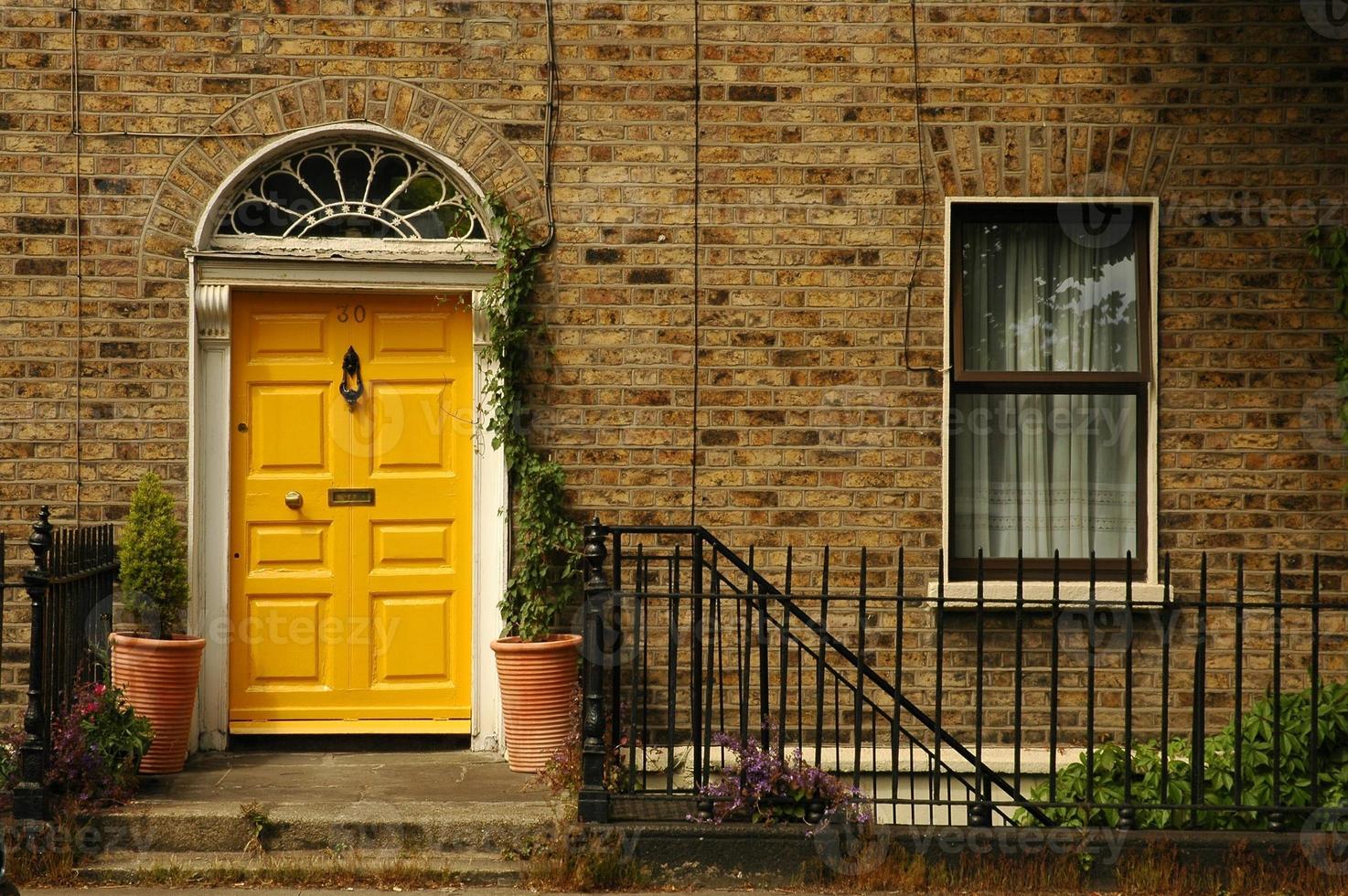 La entrada a una casa de ladrillo con una puerta amarilla foto
