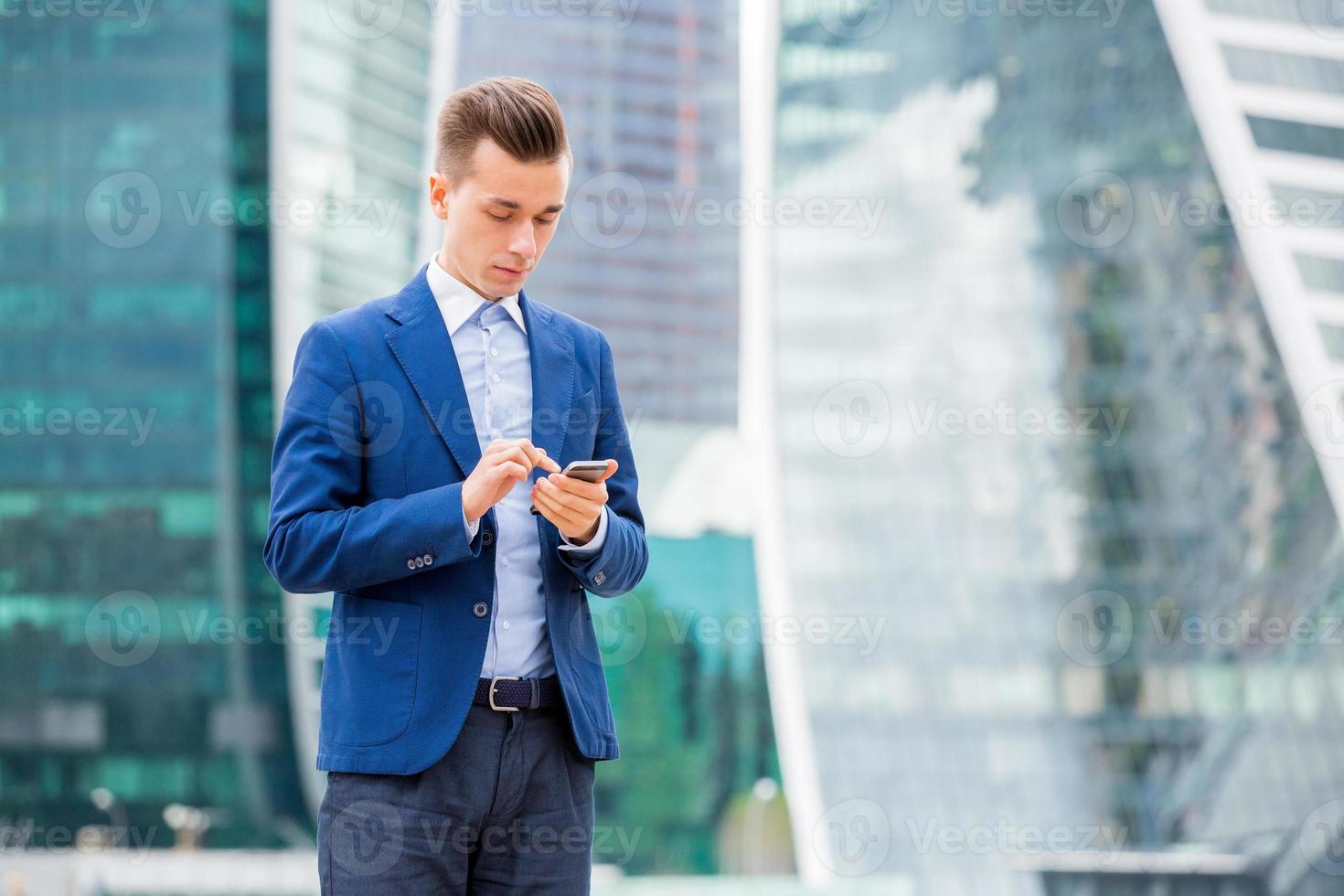 Handsome businessman in suit with smart phone in hand photo