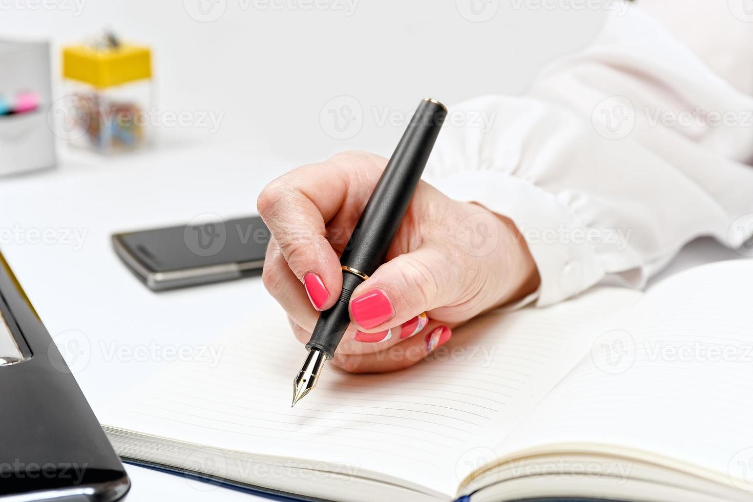 primer plano de la mano femenina con laptop, smartphone y notebook foto