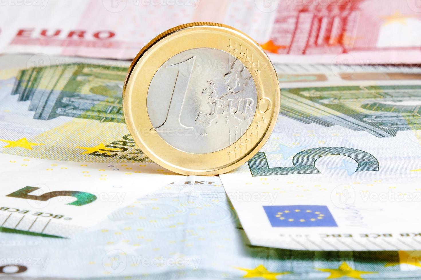 one euro coin on banknotes photo