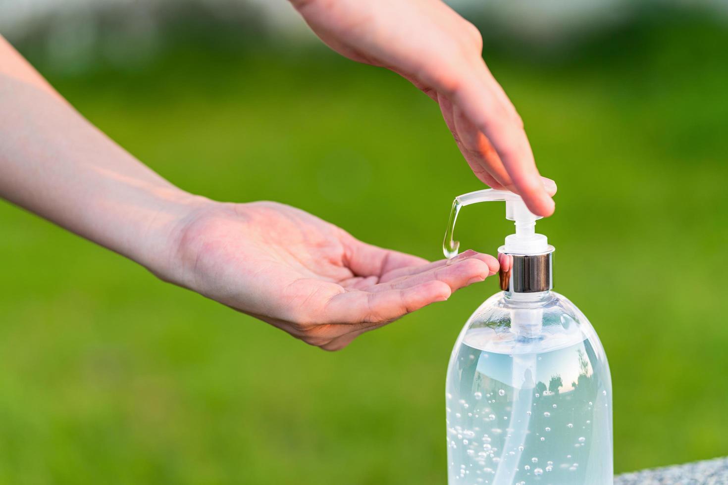 A person using hand sanitizer gel pump outside  photo