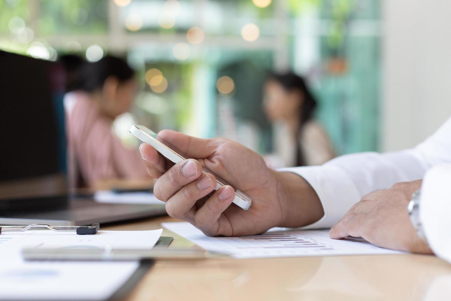 Business person at desk using mobile phone photo