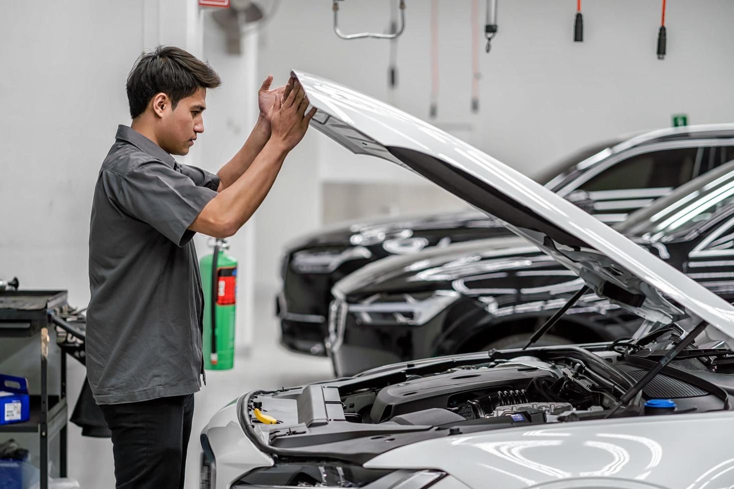 A mechanic looks under the hood of a customer's car in maintenance service center  photo