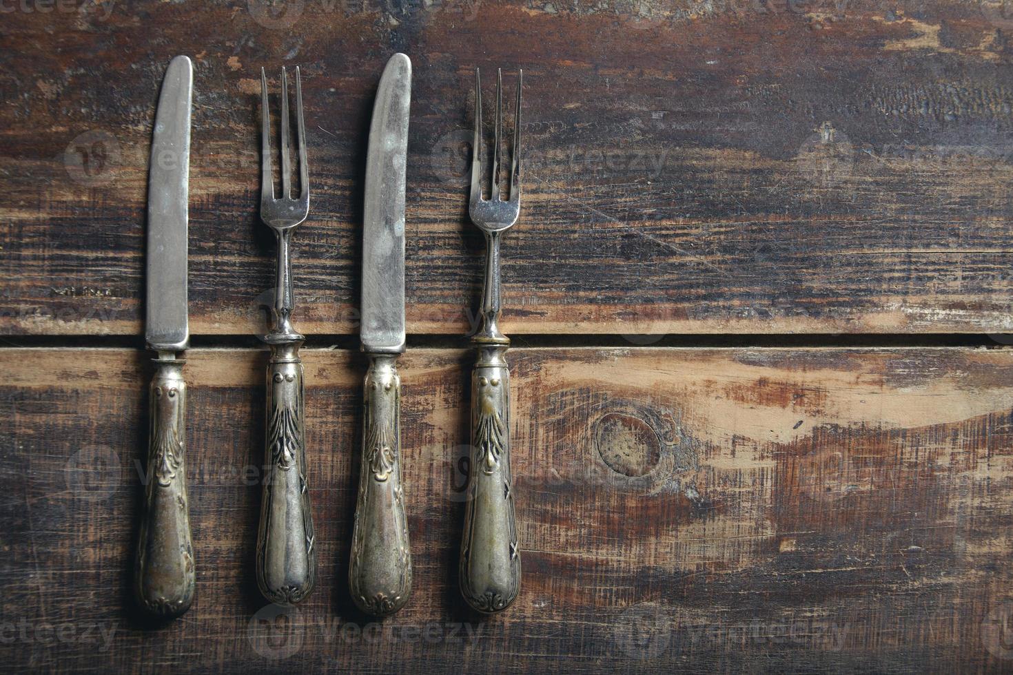 forks and knifes from above on a wooden table photo